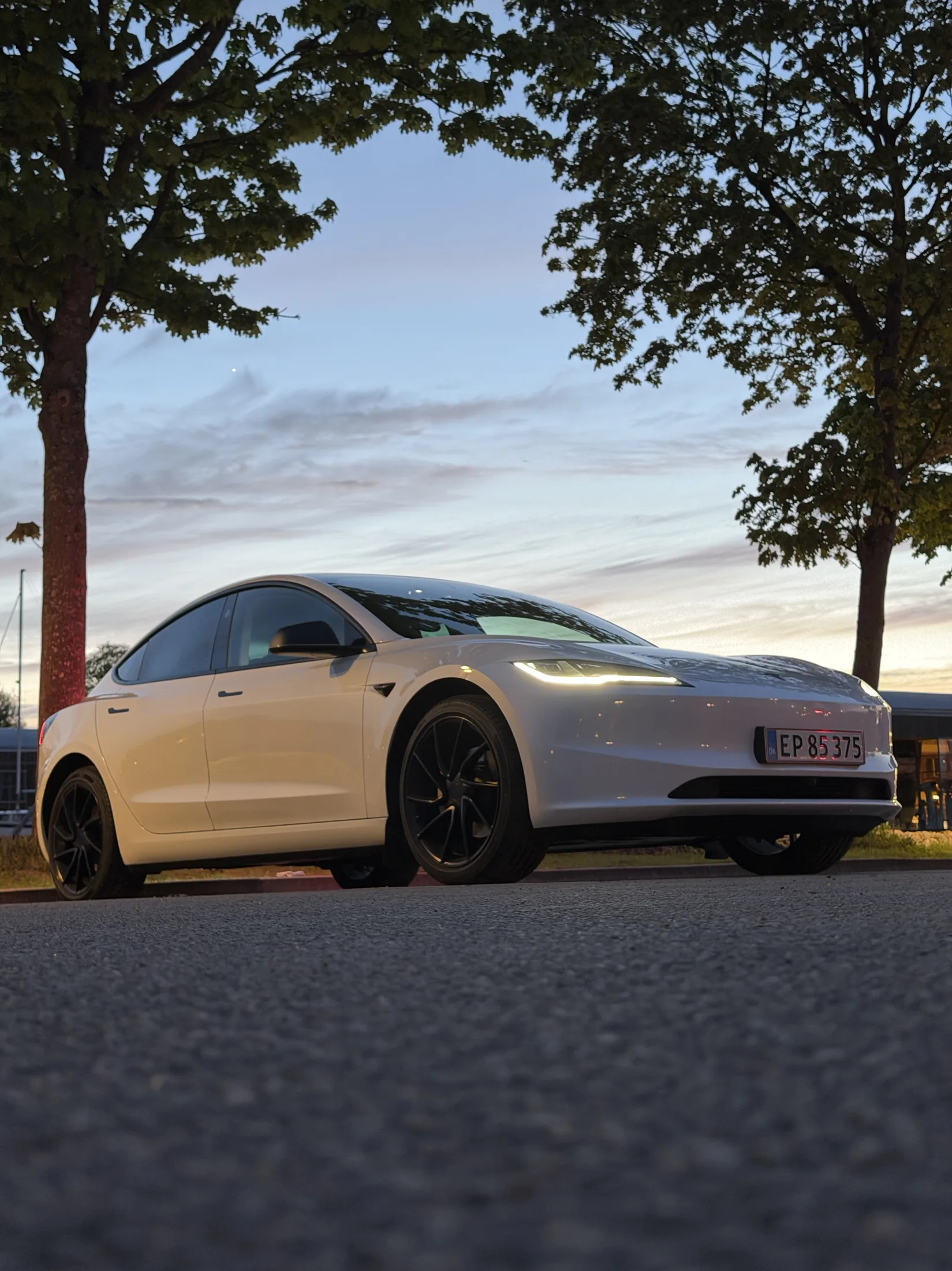 Hvid Tesla fotograferet lavt ved solnedgang
